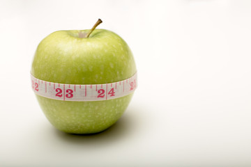Fresh green apple with a tape measure