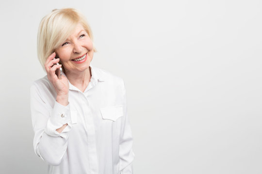 Nice picture of a lady calling t his family using a new smartphone. She adores new technologies and like to try to use new devices as much as she can. Isolated on white background.