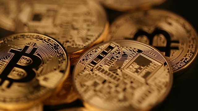 Gold coins bitcoin fall on black table