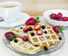 Home-made waffle baking. Waffles with berries