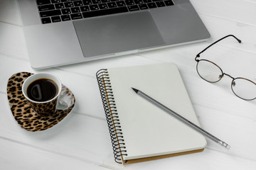 Business planner with pencil on a white wooden table. Cup of espresso coffee and notebook with list...