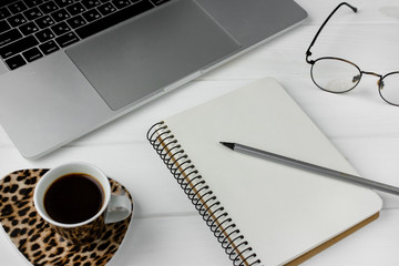 Business planner with pencil on a white wooden table. Cup of espresso coffee and notebook with list to do. Preparing for business meeting. Computer glasses and laptop. Isolated working utilities