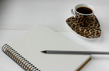 Business planner with pencil on a white wooden table. Cup of espresso coffee and notebook with list to do. Preparing for business meeting. Computer glasses and laptop. Isolated working utilities