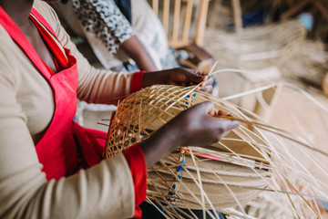 woman weaving basked out of bamboo in Rwanda Africa - obrazy, fototapety, plakaty