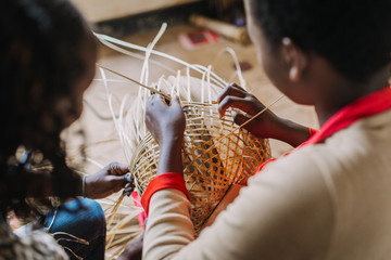 Woman weaving basked out of bamboo in Rwanda Africa