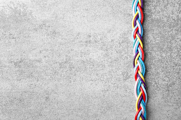 Braided strings on light background. Unity concept