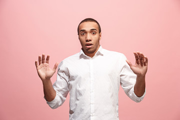 Naklejka premium The young attractive man looking suprised isolated on pink