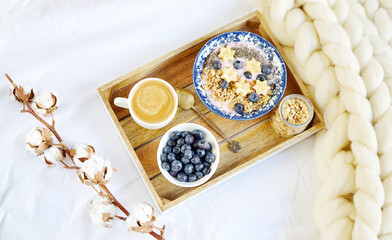 Fresh Breakfast Yogurt with Muesli Banana Berries Chia Seeds Granola Cotton Flower White Giant Knit Blanket Bedroom Healthy Lifestyle
