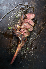 Barbecue dry aged wagyu tomahawk steak sliced as close-up on old board