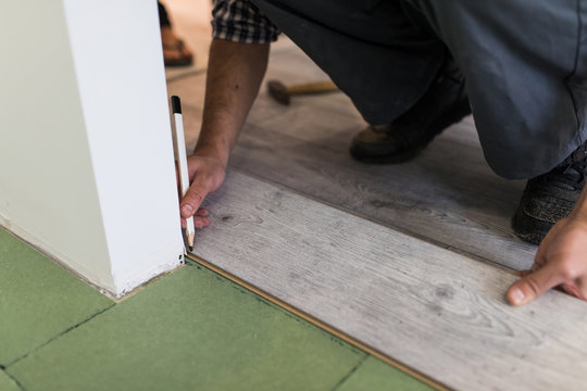 close up of male hands intalling wood flooring