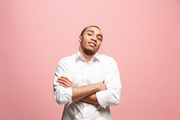 The happy business man standing and smiling against pink background.