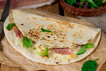 Italian flatbread piadina with prosciutto ham and mozzarella cheese