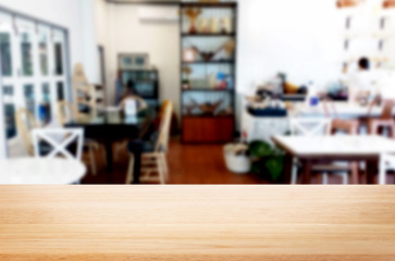 Selected focus empty brown wooden table and Coffee shop or restaurant blur background with bokeh image. for your photomontage or product display.