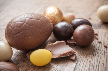 closeup of various chocolate easter egggs on wooden background