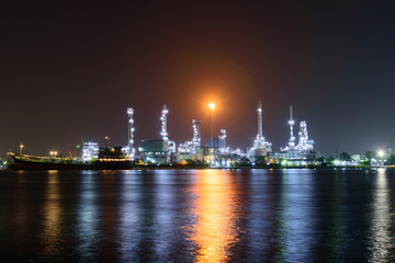 Oil refinery at the river in night time / Big Factory in night time