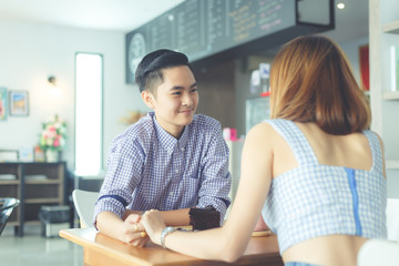 Fototapeta premium lesbian couple holding together on the cafe table with a lovely moment.
