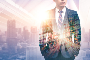 The double exposure image of the businessman wearing a suit during sunrise overlay with cityscape and binary code image. the concept of digital, developers, internet of things and technology