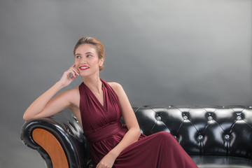 Beautiful fashion woman model sitting and smiling posing on sofa