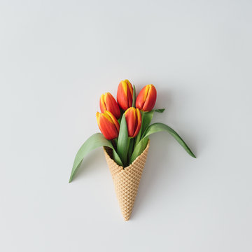 Ice cream cone with tulip flowers. Minimal spring concept. Flat lay.
