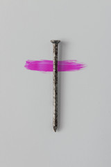 Nail of The Holy Cross of Jesus Christ with pink paint. Minimal Easter concept.