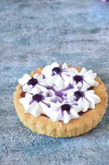 Fototapeta na wymiar Dessert with jam and cream. Dessert with cream in a basket. Cake in lilac tones. Dessert on the background of flowers.