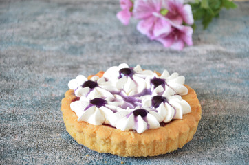 Obraz na płótnie Canvas Dessert with jam and cream. Dessert with cream in a basket. Cake in lilac tones. Dessert on the background of flowers.