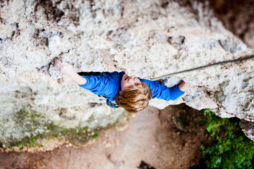 Fototapeta na wymiar The child climbs the rock.
