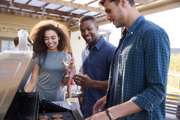 Group Of Friends Enjoying Barbecue At Home Together