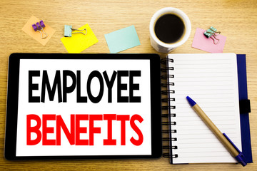 Word, writing Employee Benefits. Business concept for Compensation Career Written on tablet laptop, wooden background with sticky note, coffee and pen