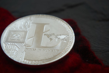 Silver litecoin on the gray stone surface