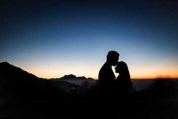 Couple in love silhouette in front of mountains