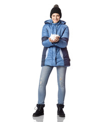 Portrait of a young girl with a smile in winter clothes with snow in hands.