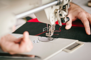 A sewer threading a needle in the sewing machine.