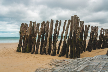 Wooden poles on beach during low tide in Saint-Malo, Brittany, France