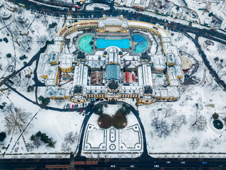 Budapest, Hungary - Aerial view of the famous Szechenyi Thermal bath from above in the snowy City Park at winter time