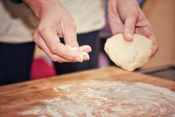 Chef pouring flour on wooden board.Selective focus.