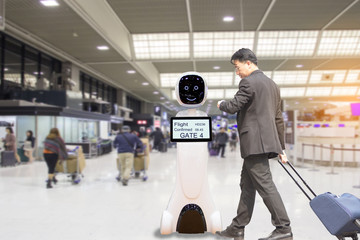 Businessmen are checking flight with intelligent robots, who serve passengers at the airport.