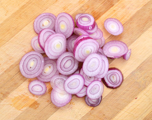 purple onion slices isolated on wooden board
