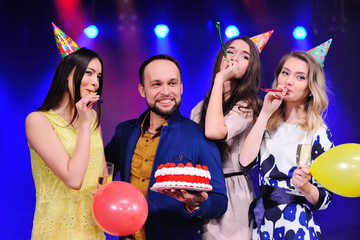 company of cheerful friends in festive hats to celebrate the event