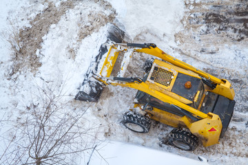 Snow-removing machine shovels snow. Top view