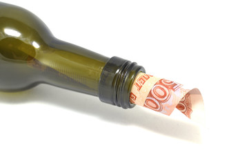 Money in bottle on white background close-up 