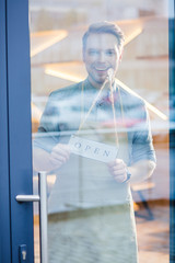 Happy delighted man holding a label tag