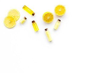 Fototapeta na wymiar Natural organic cosmetics with lemon. Lemon oil or lotion, spa salt in small bottles on white background top view copy space