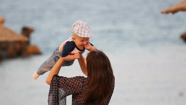 Young mother raising her baby and holding in her arms