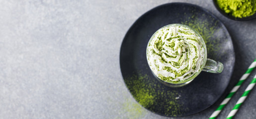 Matcha green tea latte with whipped cream. Top view. Copy space.