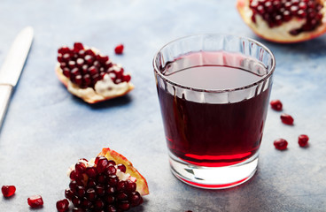 Pomegranate juice in a glass. Stone background.