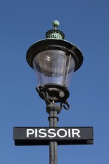 Fototapeta na wymiar Street light with pissoir sign in Copenhagen, Denmark