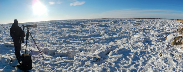 A PHOTOGRAPHER WAITING FOR POLAR BEAR AT FROZEN HUDSON BAY, MANITOBA, CANADA