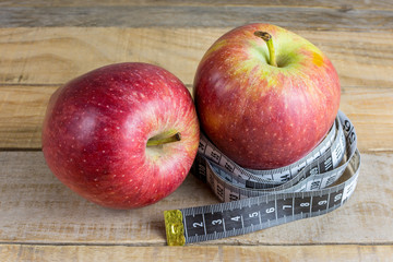 Apple with measuring tape on wooden table