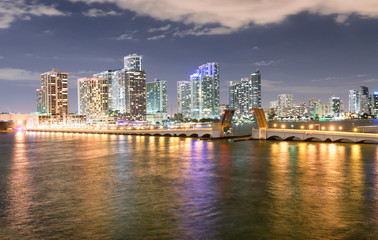 Miami night skyline from MacArthur Causeway. Buildings reflections